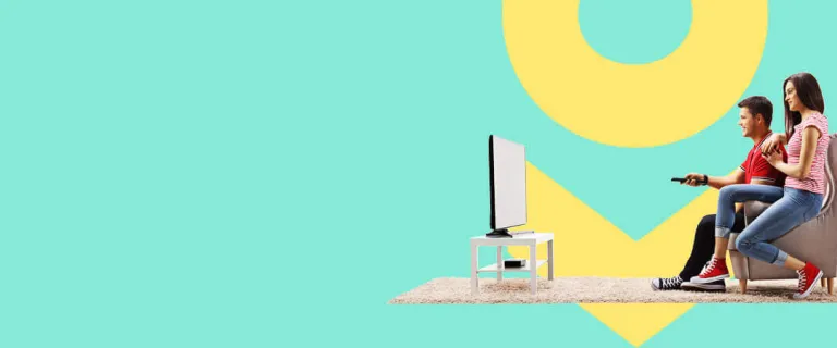 Man and woman sitting in chair watching television using satellite internet